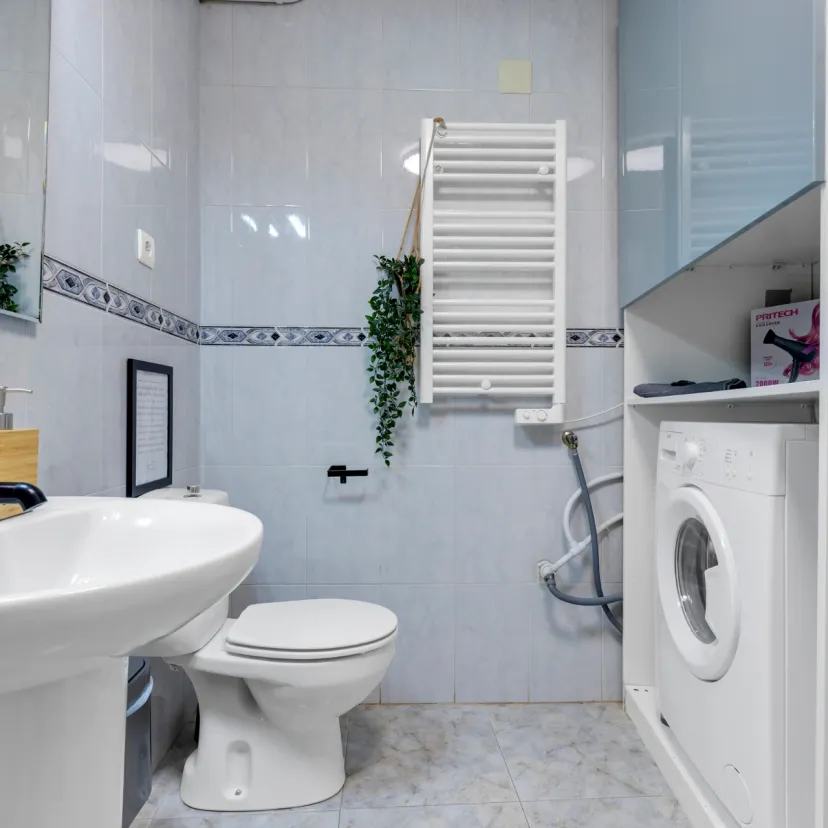 The bathroom of Apartamento Níspero features a washing machine